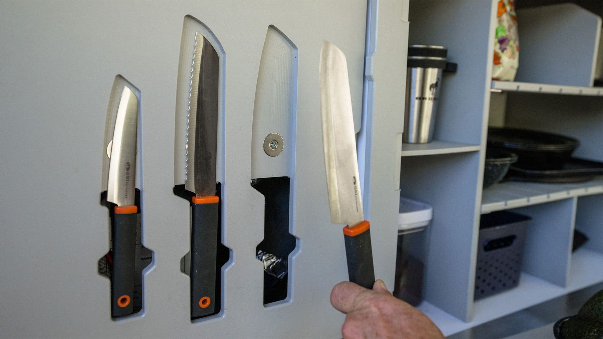 Integrated knifes are held into the cabinet face of the Escapod TOPO2 galley with magnets.