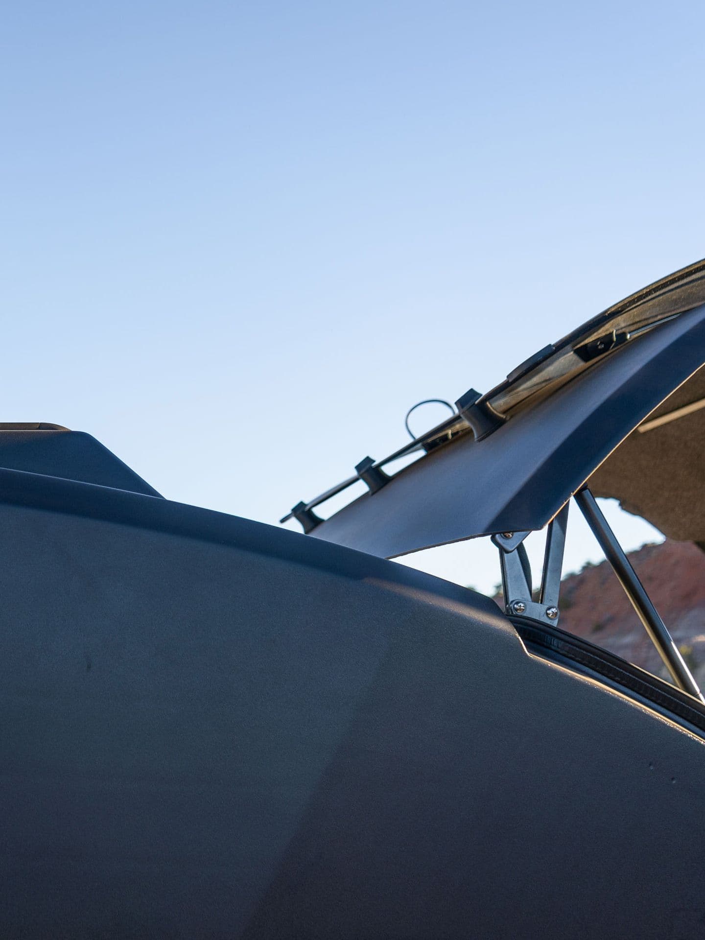 Side profile of an Escapod trailer's aerodynamic roofline, featuring a Thule roof rack system and pop-up galley hatch for storage and convenience.