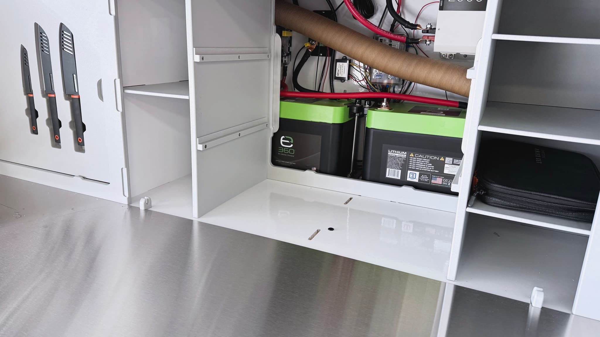 A detailed view of the utilities closet in the galley of the Escapod TOPO2, featuring expion 360 lithium ion batteries.